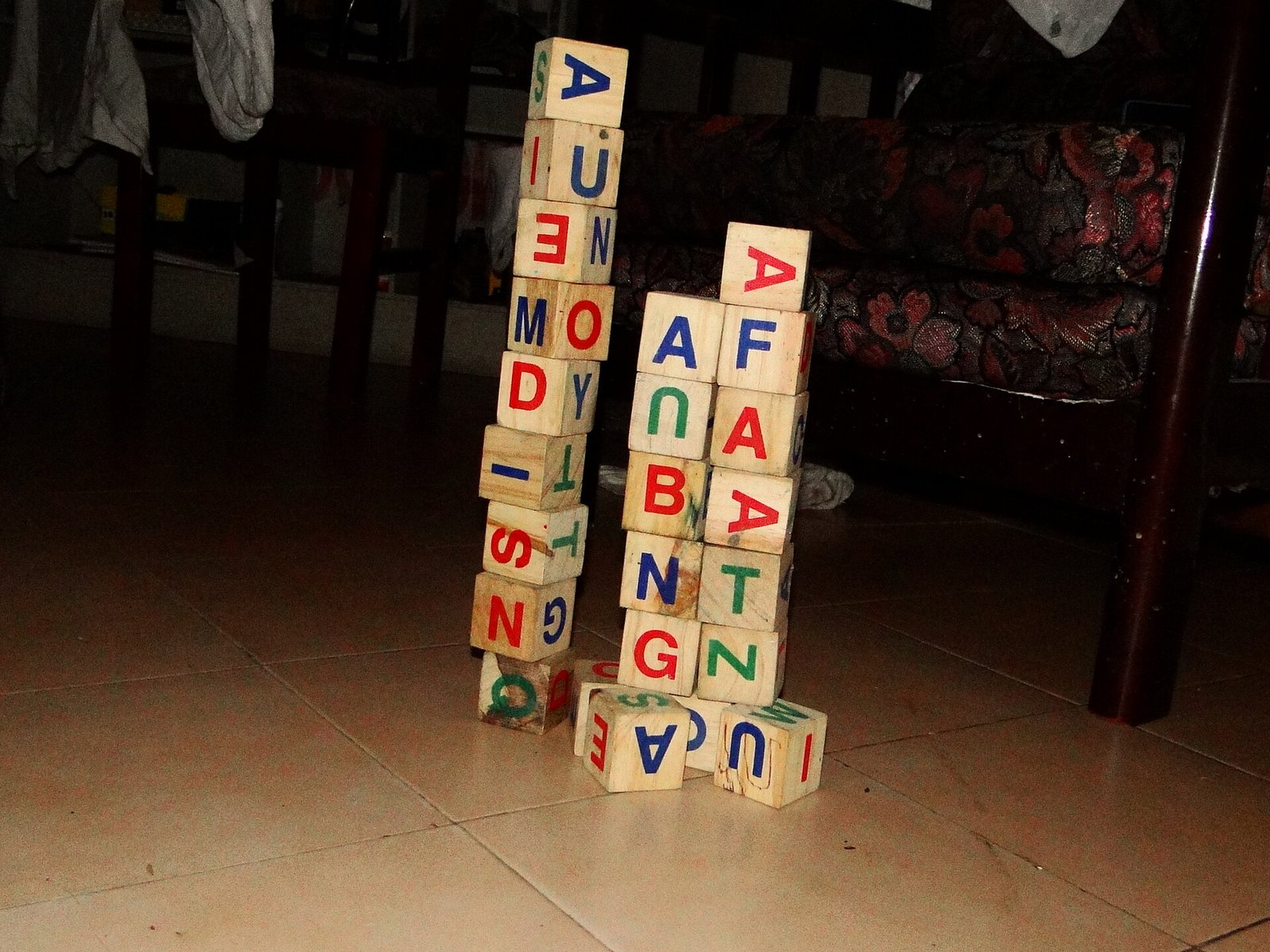 Dos torres de cubos de madera con letras de colores sobre un piso de loseta