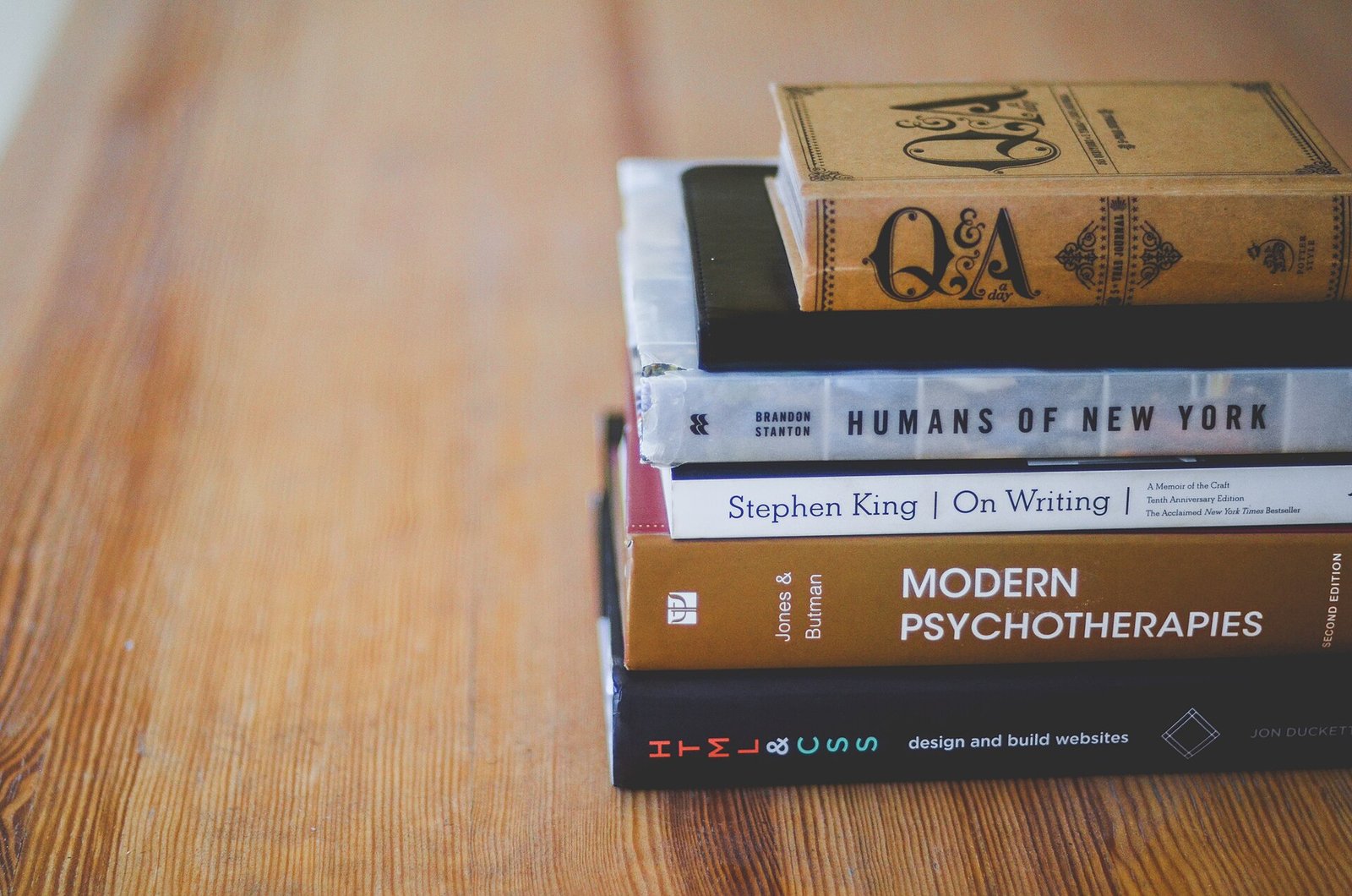 Pila de libros sobre una mesa de madera