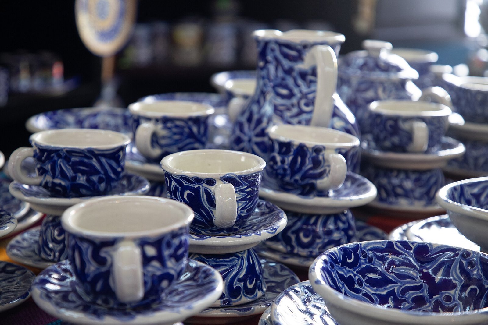 Tazas, platos y jarras de talavera poblana decorados en azul sobre fondo blanco