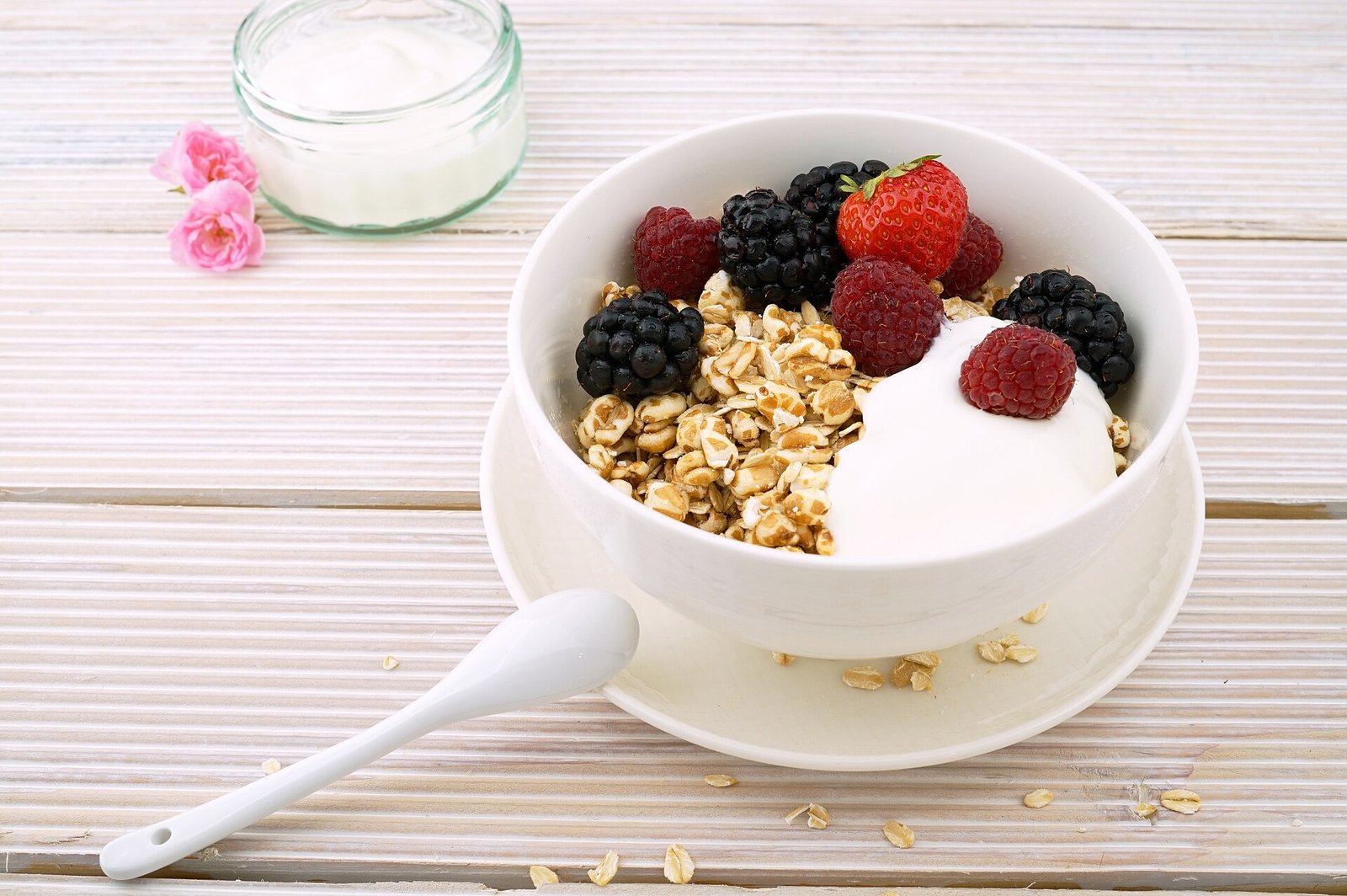 Tazón con hojuelas de avena, yogur, zarzamoras, frambuesas y una fresa