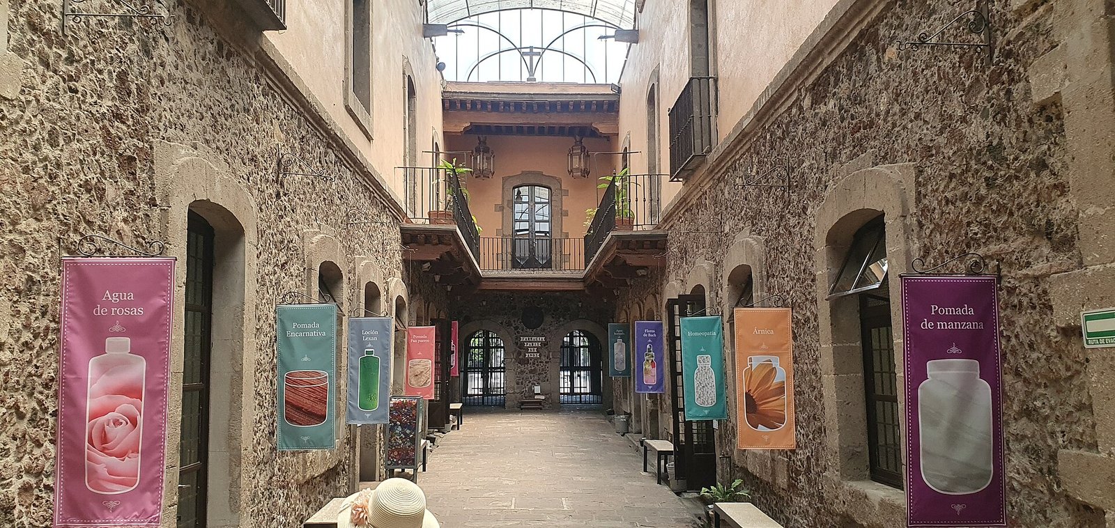 Patio interior del anexo de la Farmacia París en República de El Salvador 81, con pendones de agua de rosas y pomada de manzana