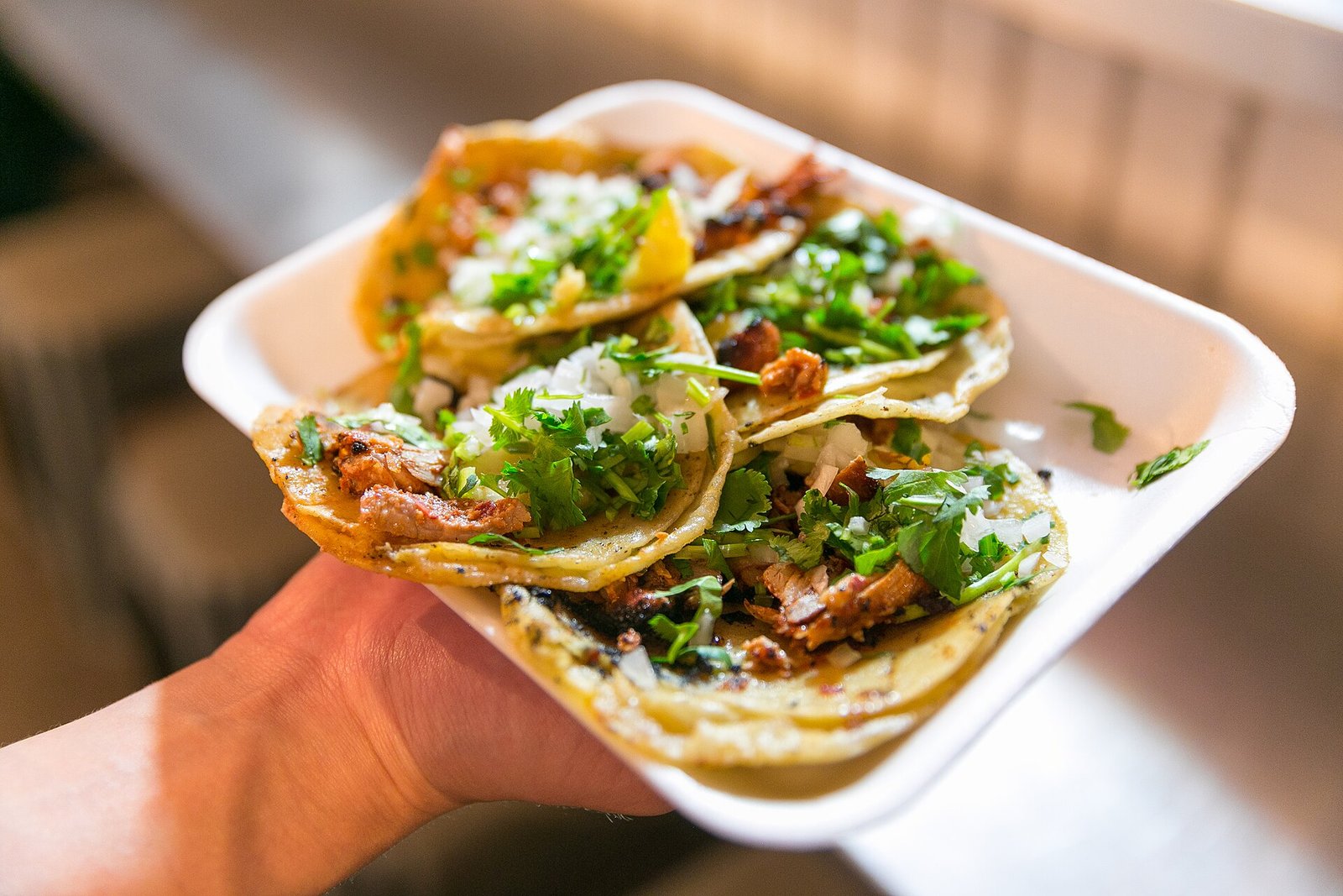 Plato con tacos al pastor servidos con cebolla y cilantro