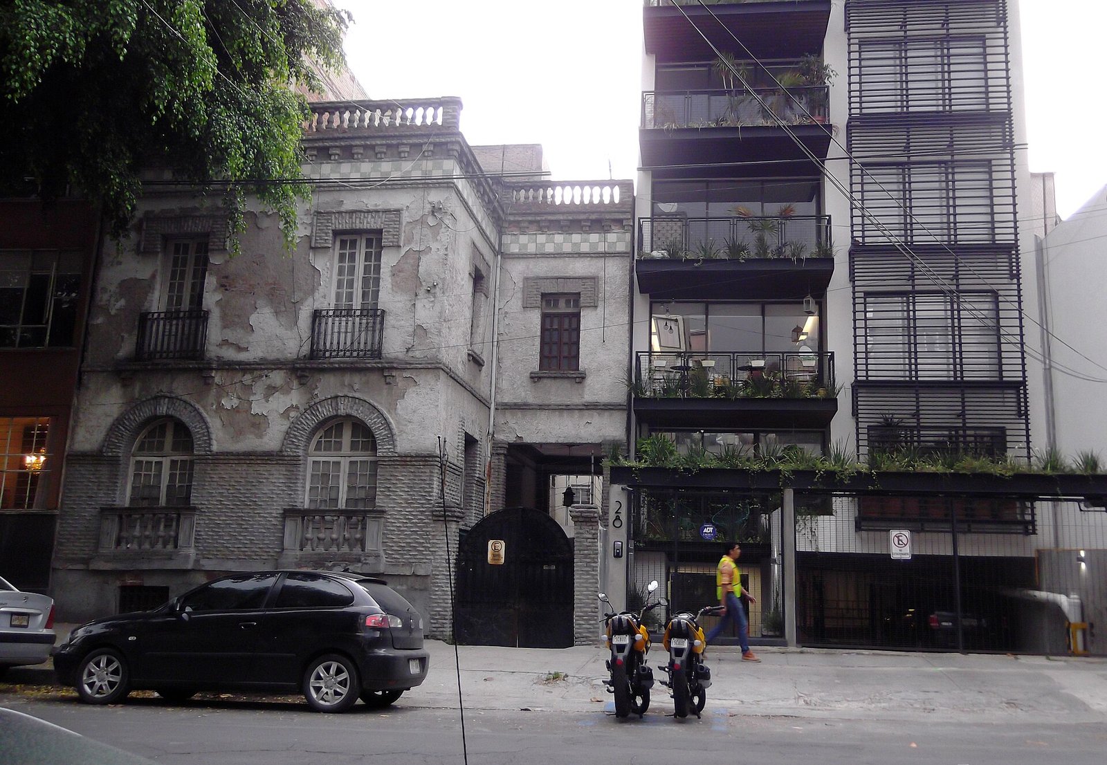 Casa de estilo neoclásico de los años veinte junto a un edificio de departamentos moderno en la colonia Roma