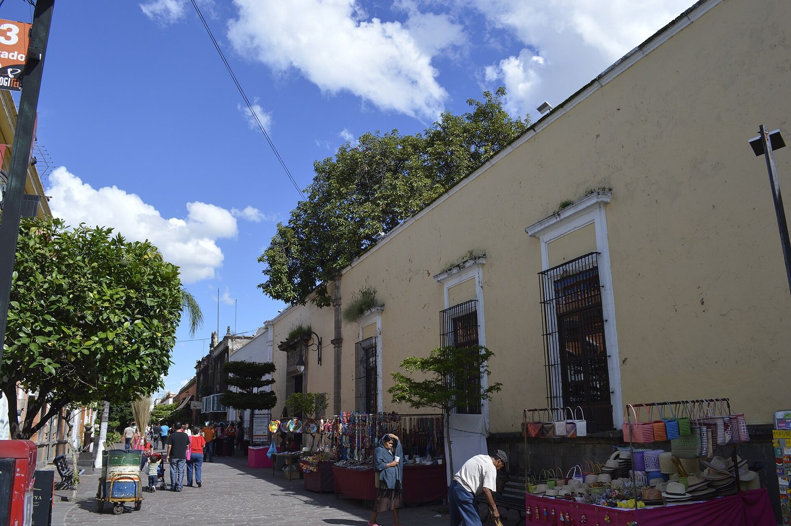 Fachada del Museo Regional de la Cerámica en el centro de Tlaquepaque, con puestos de artesanías en la banqueta