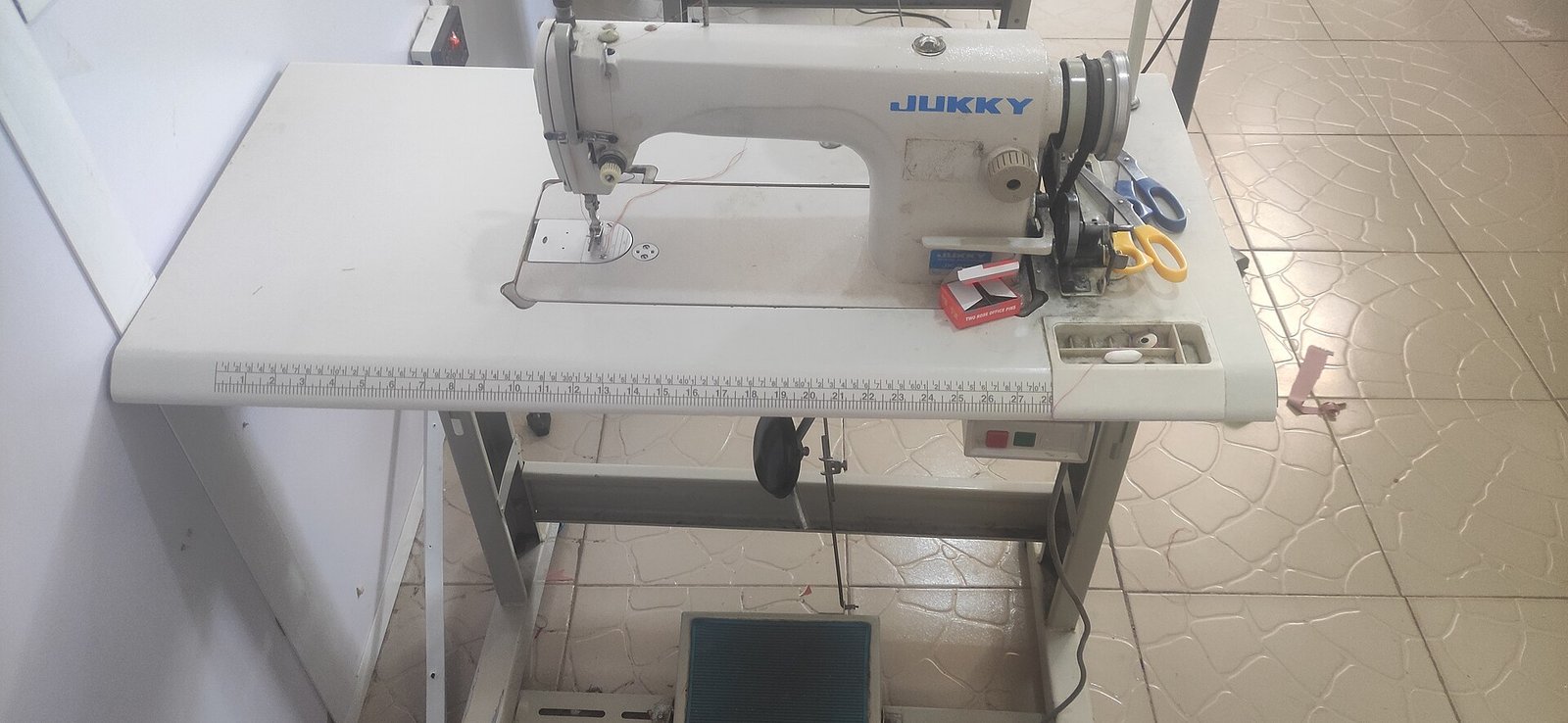 Máquina de coser industrial sobre su mesa de trabajo en un taller de costura