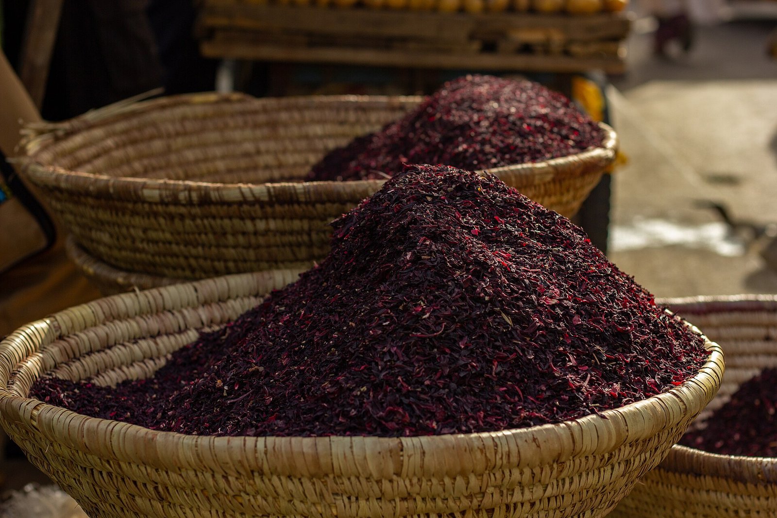 Flor de jamaica seca apilada en canastas de palma en un mercado