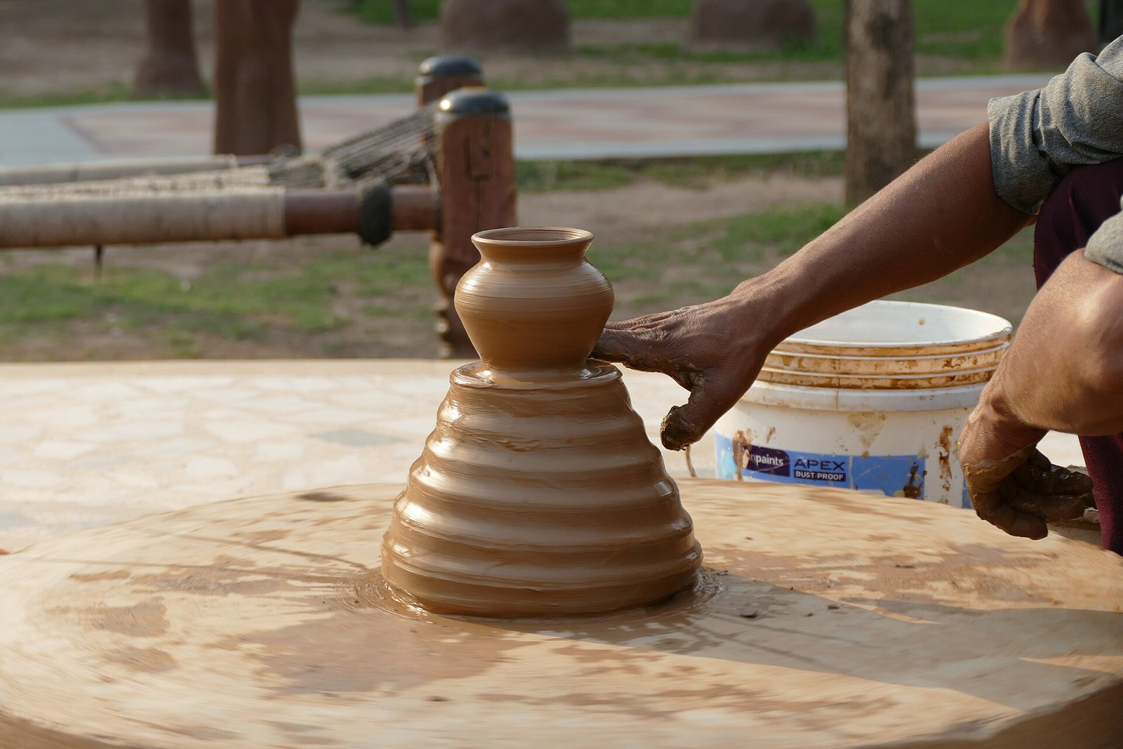 Manos de un alfarero modelando una vasija de barro sobre el torno