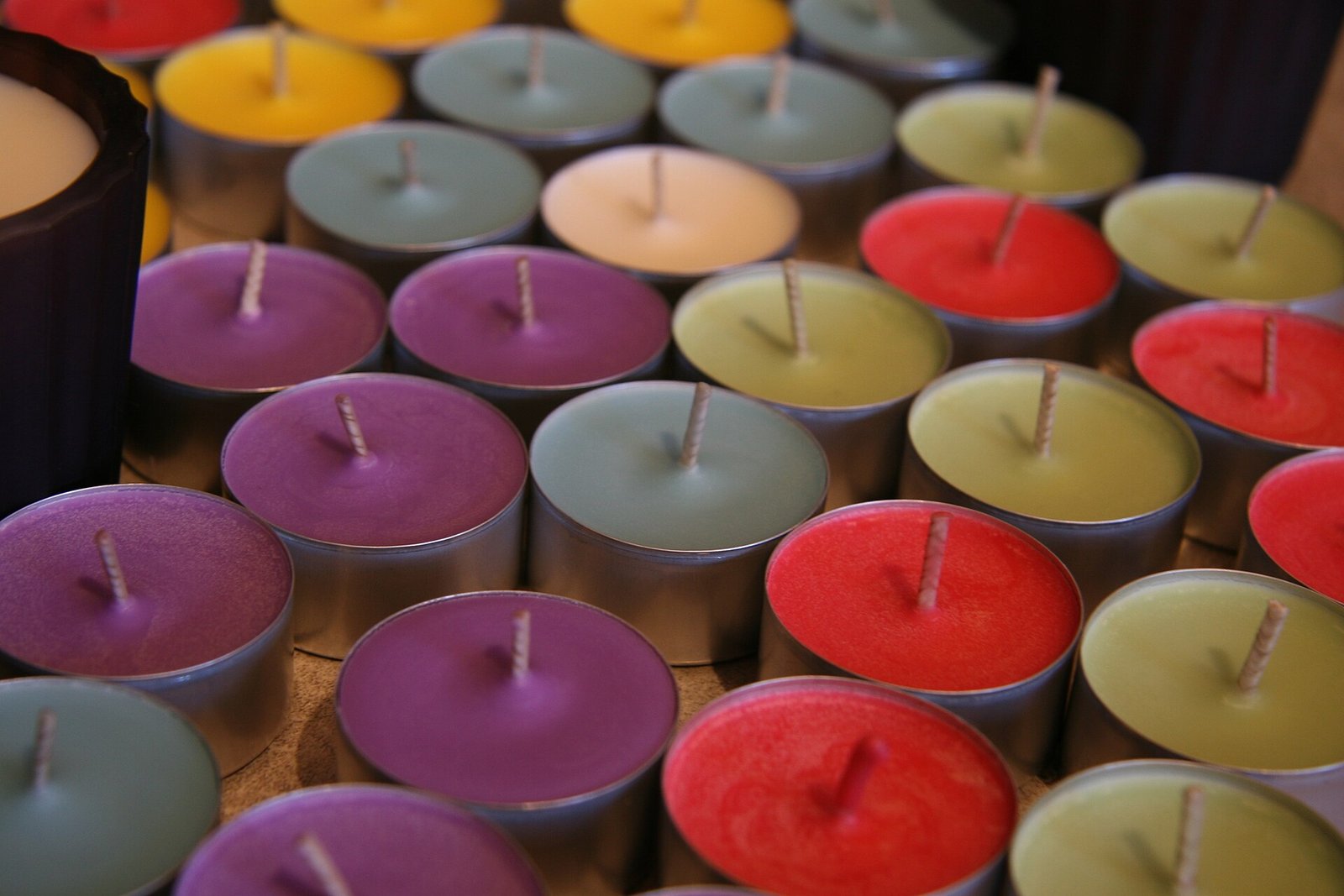 Velas de soya hechas a mano en contenedores metálicos de varios colores
