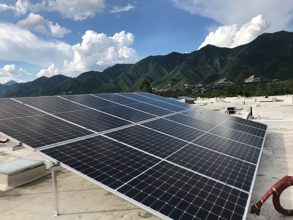 Paneles solares instalados en una azotea de Monterrey con la sierra al fondo