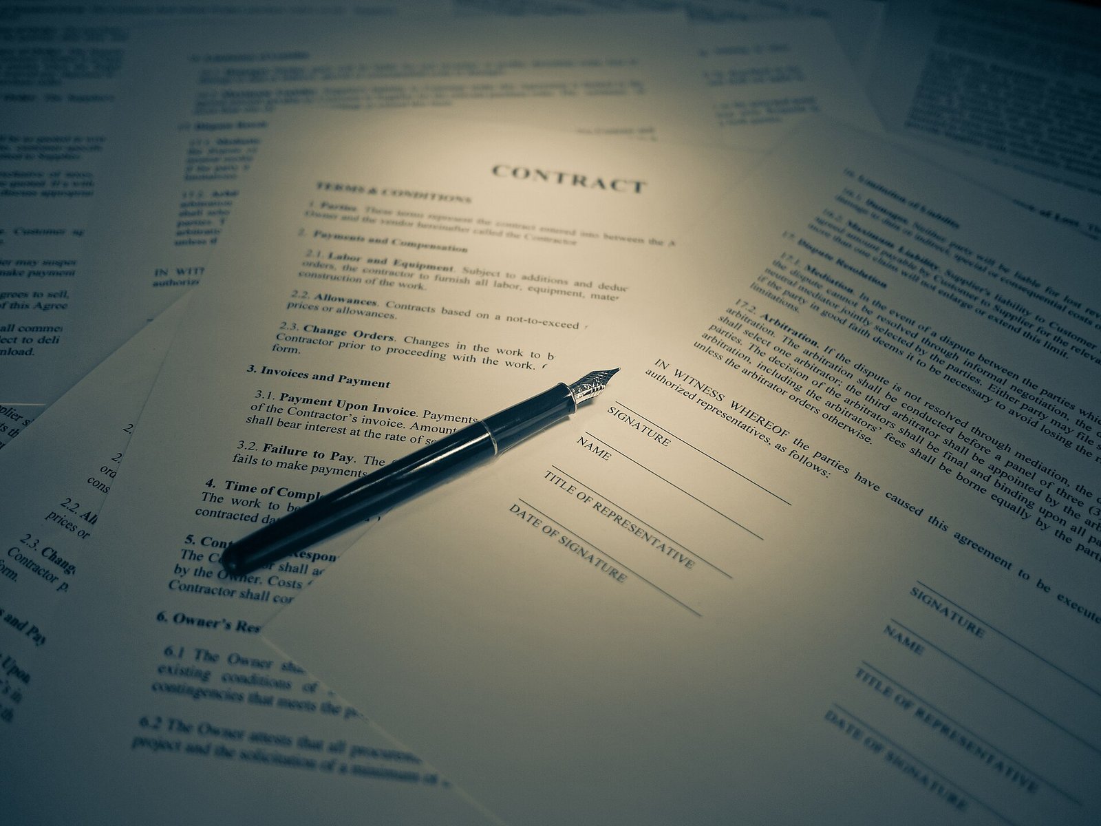 Pluma fuente sobre un contrato impreso con espacios para firma