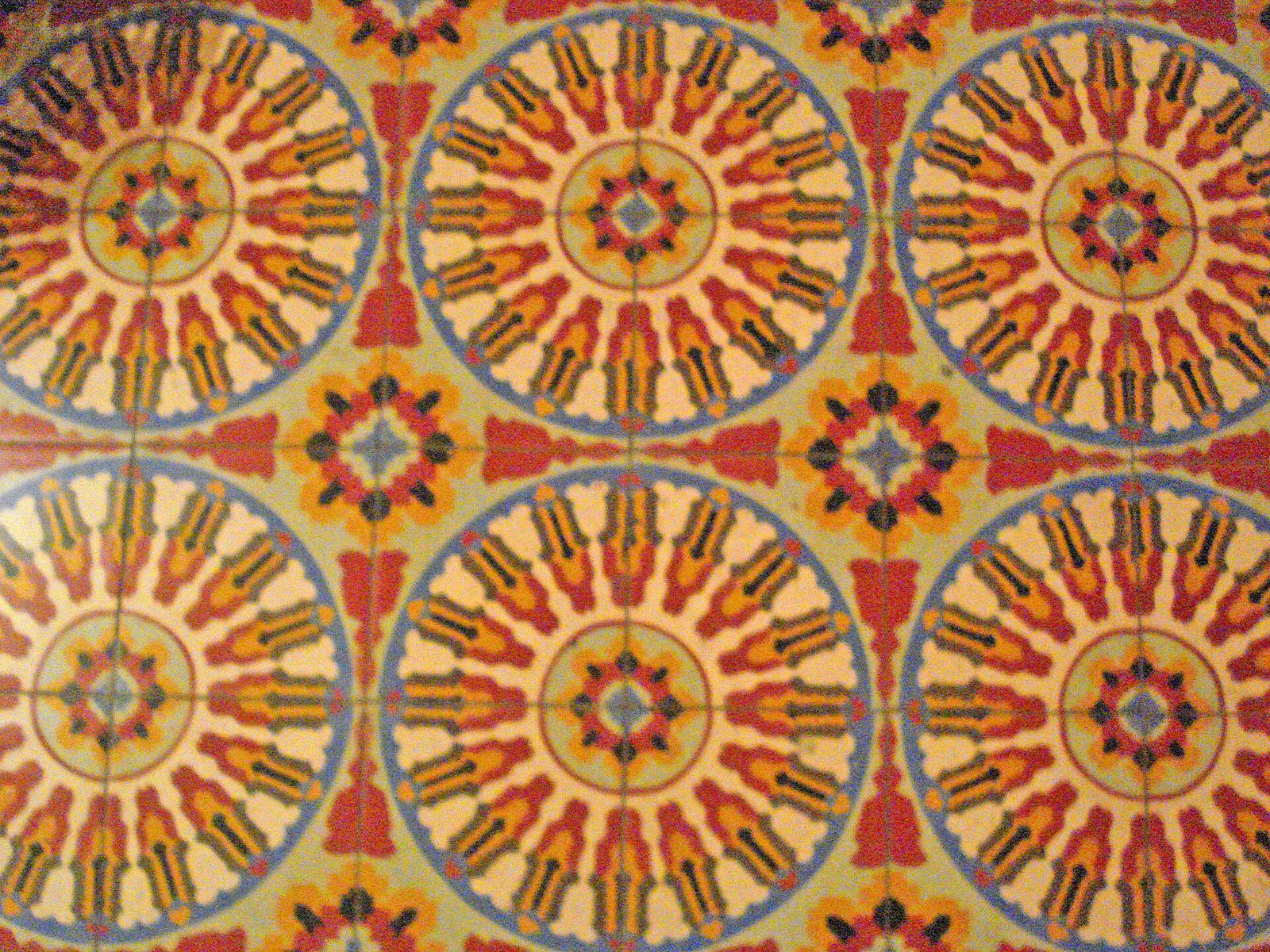 Piso de mosaicos de pasta yucatecos con un diseño de círculos en rojo, amarillo y azul